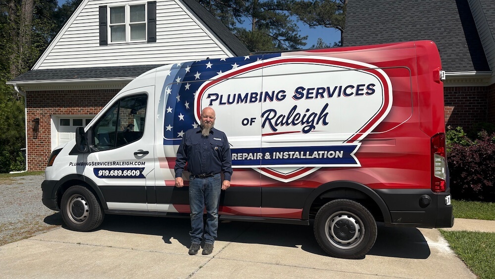 David Dobbs, owner of Plumbing Services of Raleigh, standing in front of his branded service van in Raleigh, NC